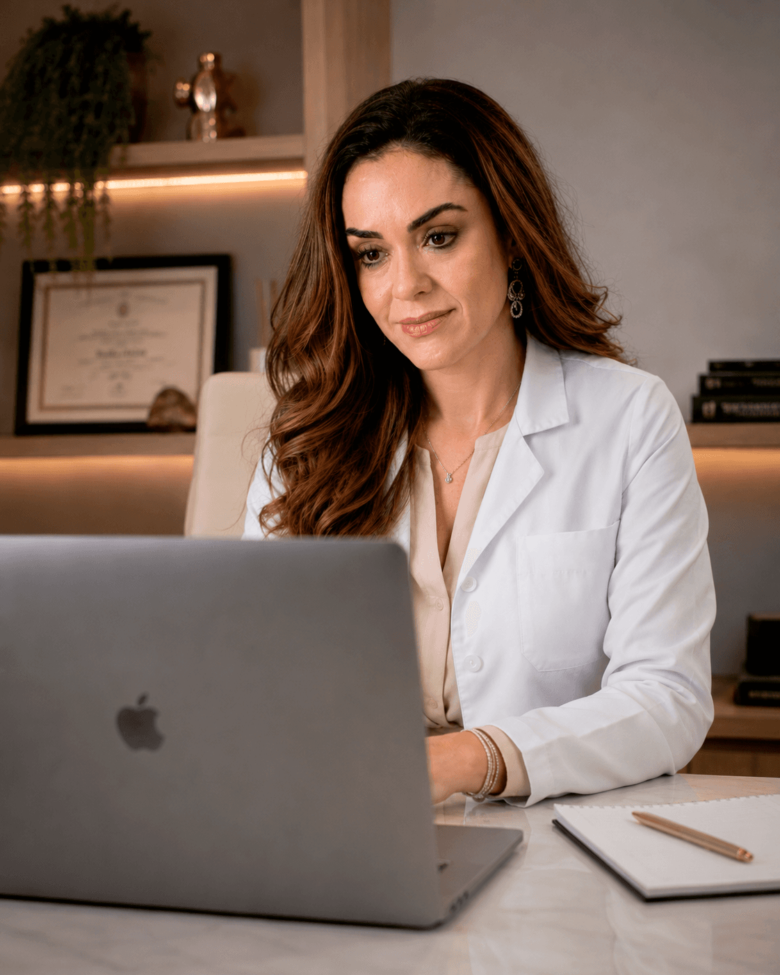 Dra. Lizeta Cristine Lemes Saúde diante do computador no consultório, durante uma teleconsulta